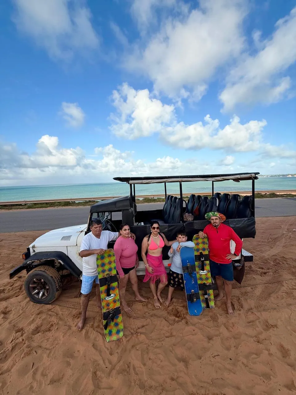 Grupo com pranchas de sandboard ao lado do Jeep