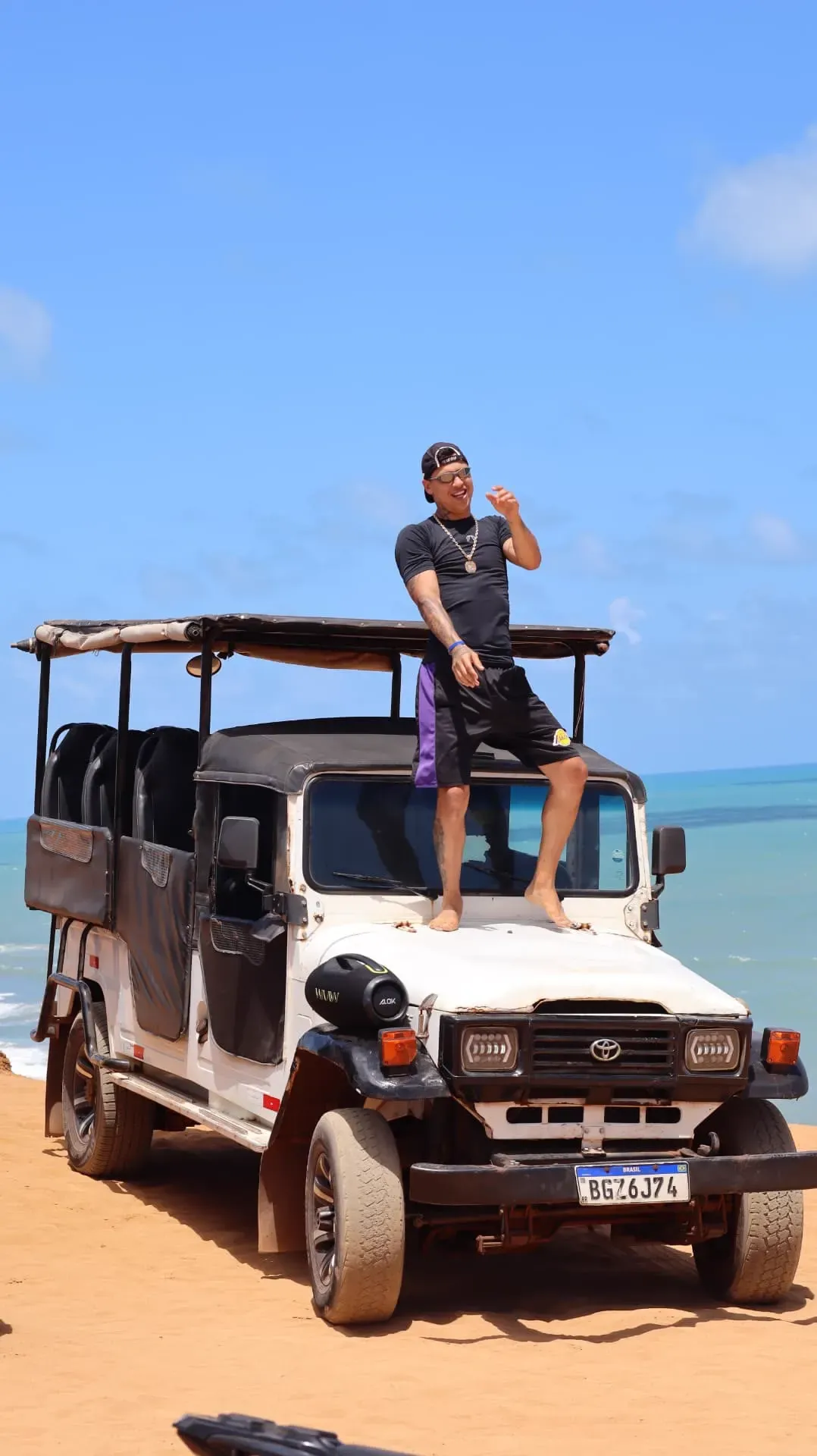 Guia em cima do jeep 4x4 na praia em Pipa